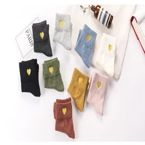 Vue détaillée de chaussettes mi-hautes pour femmes en coton avec broderie de cœur doré colorée.