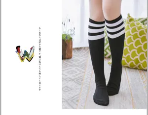 Close-up detail of women's black knee high socks featuring three white stripes on top cuff.