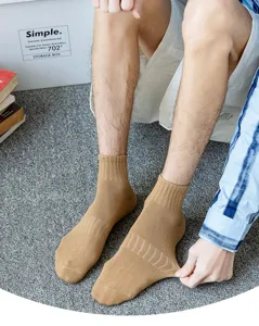 Calcetines de tubo medio de algodón caqui para hombres, detalle con tela suave y arco elástico.