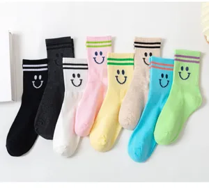 Detailansicht süßer Damensocken mit lächelndem Gesicht und gestreiften Rippbündchen.