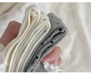 Nahaufnahme von Damen Socken mit Spitze, Schleife und Punkten aus weichem Baumwollstoff.