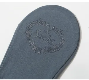 Nahaufnahme von grauen Vorderfuß-Halbsocken mit rutschfesten Silikonpunkten und Herzmuster.