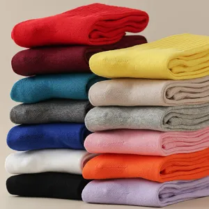 Colorful solid cotton calf socks stacked neatly, perfect for casual spring and autumn wear.