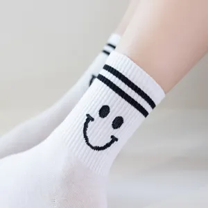 Süsse weisse Damensocken mit schwarzem Smiley-Gesicht und sportlichen doppelten Streifen.