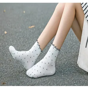 Süße japanische weiße Baumwollsocken mit schwarzen Punkten und Rüschenrand im Detail.