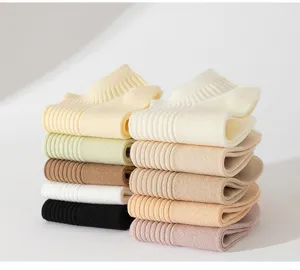 Pile nette de chaussettes courtes en tricot uni dans diverses teintes pastel et neutres.
