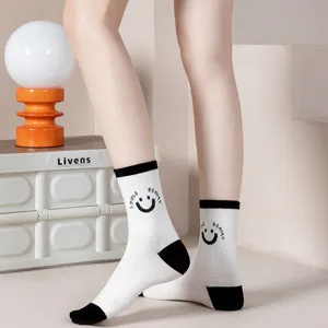 Calzini medi da donna in cotone, design alla moda in bianco e nero con simpatica faccina felice.