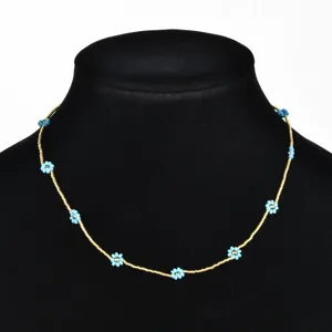 Detail shot of handmade bohemian seed bead daisy flower choker necklace in gold and blue.
