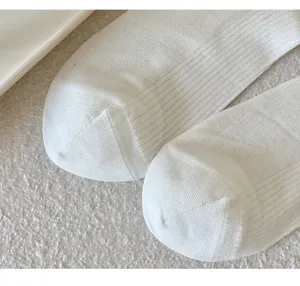 White ribbed long socks detail showcase, soft breathable material for women daily wear.