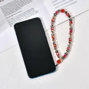 Gedetailleerd overzicht van een kleurrijke kristalen kralen telefoonkoord met smartphone.