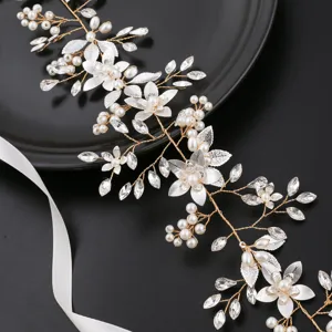 Detailed shot of handmade bridal hair vine with pearls, crystals, and gold wire accents.