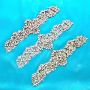 Closeup of sparkling rhinestone pearl applique patches for bridal wedding dress sashes belts.
