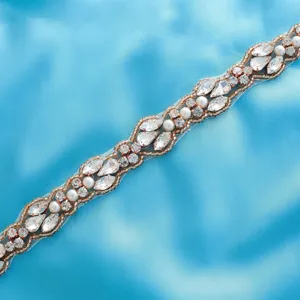 Close-up detail of glittering rhinestone and pearl beaded trim applique for bridal dress.