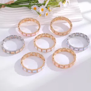 Vista detallada de pulseras elásticas cuadradas geométricas de cristal en oro y plata.