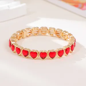 Close-up of a stylish red heart-shaped crystal stretch bracelet with golden metal details!