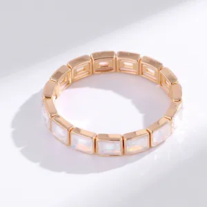 Elegante pulsera elástica dorada de eslabones cuadrados con piedras de cristal iridiscentes.