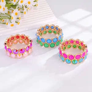 Detailed view of colorful crystal stretch bracelets with gold-tone metal settings and sparkle.