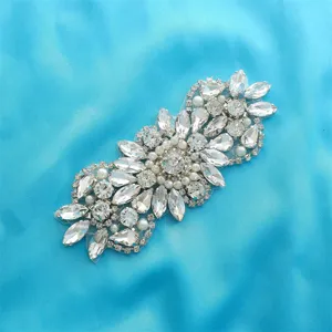 Detailed view of crystal rhinestone bridal belt applique, sparkling diamond wedding dress patch.