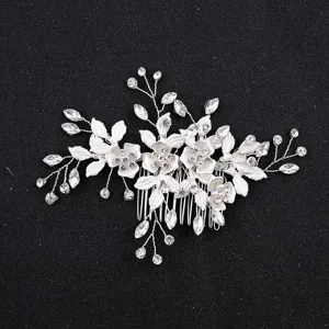 Close-up of a silver bridal hair comb with sparkling crystals and delicate floral leaves.