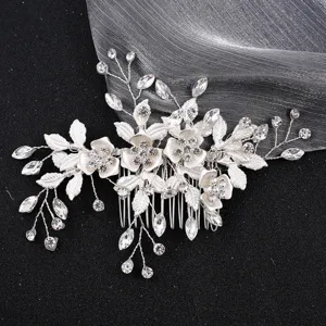Detail view of silver bridal hair comb with shimmering crystals and intricate floral design.