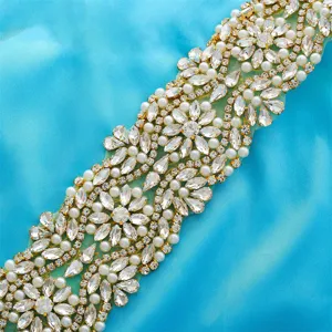 Exquisite rhinestone and pearl bridal belt applique detail, sparkling crystals on blue fabric.