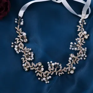 Close-up detail of bridal pearl and crystal hair vine with white ribbon on blue satin.