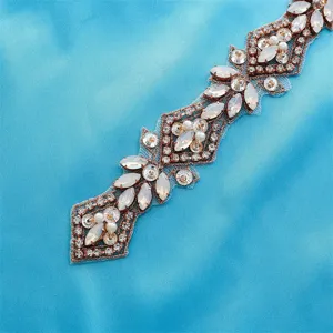 Close-up detail of a bridal rhinestone applique belt with shimmering crystals and pearls.