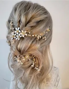 Exquisite bridal hair vine detail shot, featuring delicate leaf and pearl flower design.