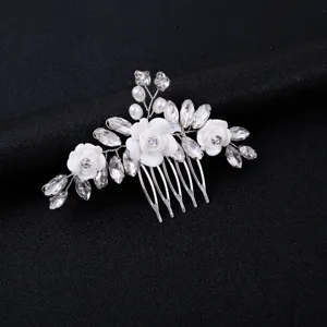 Handmade bridal hair comb with white floral design, sparkling crystals and pearls for weddings.