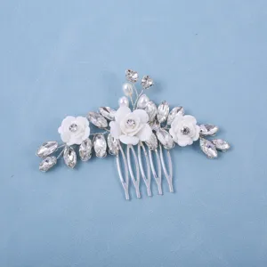 Close-up view of the exquisite bridal hair comb featuring sparkling rhinestones and white flowers.