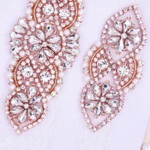 Detailed close-up view of elegant rose gold rhinestone and pearl bridal lace garter appliques.