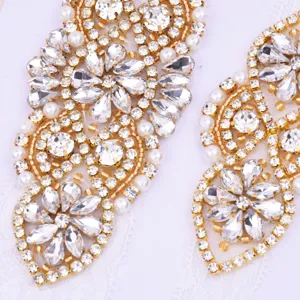 Detailed close-up of sparkling rhinestone pearl lace applique, elegant gold trim craft patch.