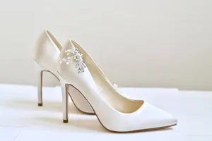 Vue détaillée d'escarpins de mariée blancs élégants en satin avec pinces à chaussures en perles.