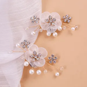 Detailaufnahme von exquisiten Strass-Perlen-Blumen-Schuhclips mit Netzblättern und Golddraht.
