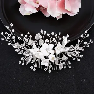 Nahaufnahme der handgefertigten weißen Keramikblume und Kristall Strass Braut Haarkamm Detail.