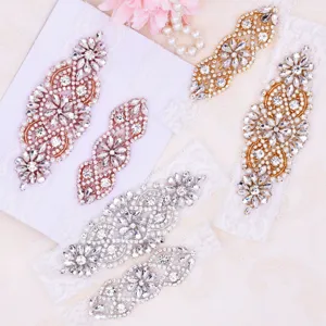Detailed view of sparkly rhinestone lace bridal garter set in various metallic finishes.