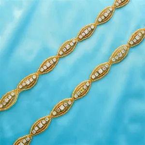 Detailed shot of golden rhinestone and beaded trim for wedding dress belt, sparkling crystal.