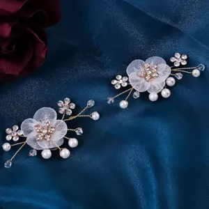 Nahaufnahme von Brautschuh-Clips mit transparenten Mesh-Blumen, funkelnden Strasssteinen und Perlen.