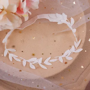 Dettaglio giarrettiera da sposa in pizzo bianco con foglie, elegante fascia per coscia.
