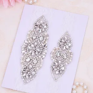 Detailed view of sparkling rhinestones and white lace ornaments on a wedding bridal garter.