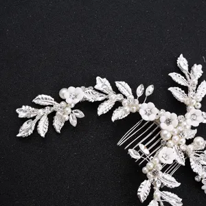 Bridal hair comb detail featuring silver metal leaves, pearls, rhinestones, ceramic flowers.