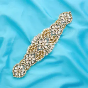 Détail d'applique de ceinture de mariée en strass, cristaux étincoyants sur base dorée.
