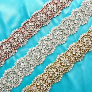 Detailed view of three rhinestone wedding belt appliques in rose gold, silver, and gold.