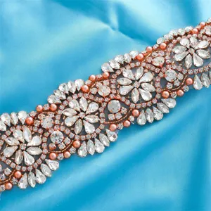 Exquisite rhinestone bridal belt applique detail with sparkling clear crystals and rose gold beads.