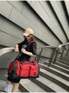 Large capacity red and black travel duffel bag with multiple pockets and shoulder strap.