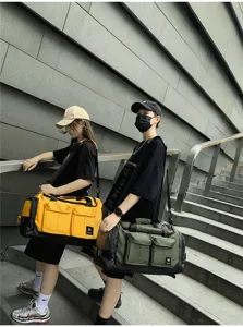 Outdoor lifestyle detail shot of large capacity travel duffel bags carried by models on steps.