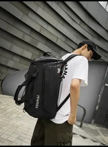 Detail view of the black travel backpack showcasing its large capacity and sturdy handle design.