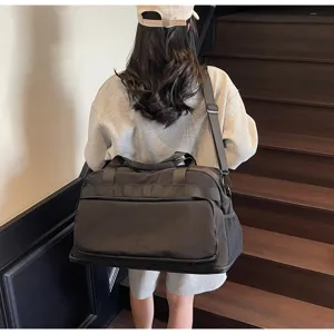 Grande borsa da viaggio grigia mostrata su modello in interno, vista dettagliata.