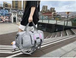 Detailed close-up of the grey sports travel duffel bag displayed in an urban outdoor scene.