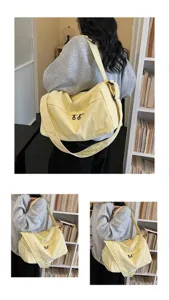 Vue détaillée du grand sac à bandoulière en toile jaune, avec sangle réglable et fermeture.
